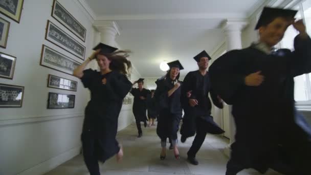 Studenter på graduation dagen löper genom korridoren — Stockvideo