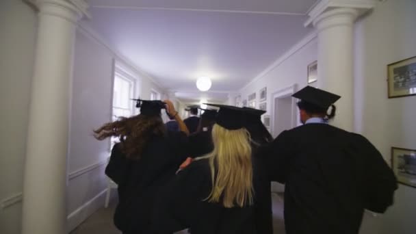 Estudiantes en el día de la graduación corriendo por el pasillo — Vídeos de Stock
