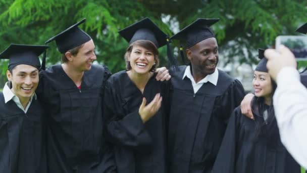 Estudiante amigos en el día de la graduación de pie al aire libre — Vídeos de Stock