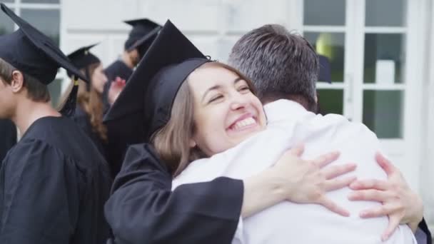 Studenter på graduation dagen är gratulerade av föräldrar — Stockvideo