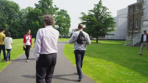 Blandad etnicitet studenter promenad runt campus — Stockvideo