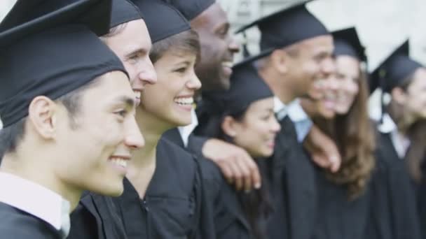 Estudiante amigos en el día de la graduación de pie al aire libre — Vídeo de stock