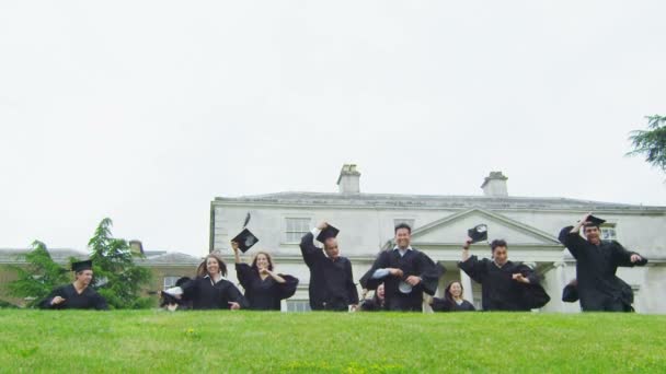 Estudiantes en el día de la graduación corren por el paisaje — Vídeo de stock