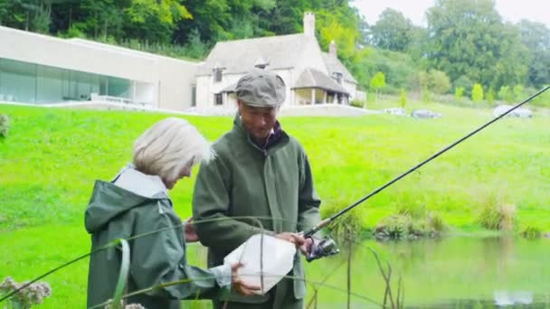 Pareja disfrutar de la pesca en el lago — Vídeo de stock