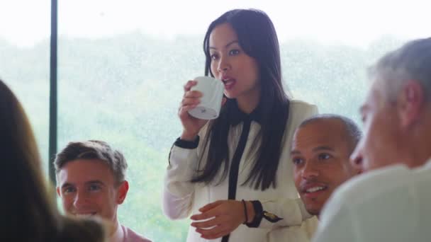 Asiatiska klunkar hennes kaffe i gruppmöte — Stockvideo