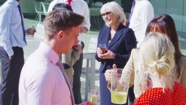 Groupe d'amis bavarder autour d'un verre à l'extérieur 