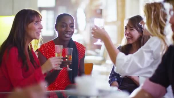 Groupe heureux d'amies bavardant autour d'un verre 