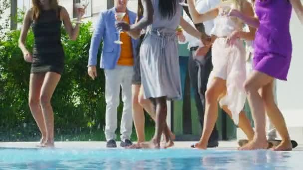 Amigos disfrutando de bebidas y bailando en la piscina — Vídeo de stock