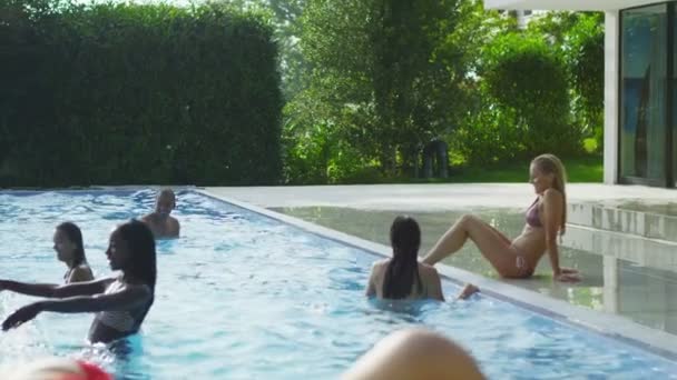 Woman lounging by pool in bikini — Stock Video