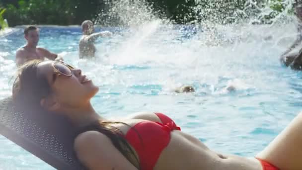 Frau lümmelt im Bikini am Pool — Stockvideo