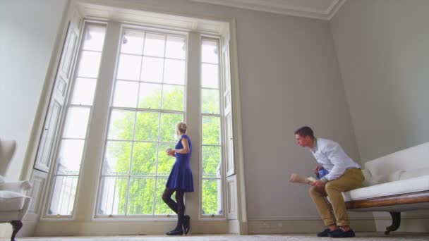 Junges Paar blickt auf Fenster — Stockvideo