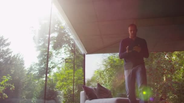 Людина в сучасному скляному будинку — стокове відео