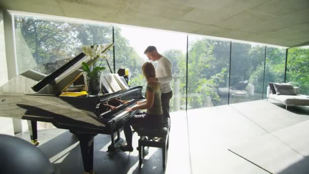 Vrouw speelt piano als haar vriendje luistert — Stockvideo