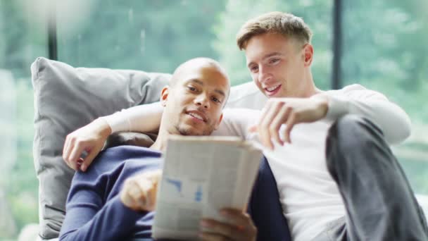 Joven pareja gay leyendo periódico — Vídeos de Stock