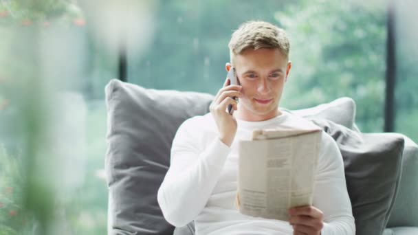 Homem fazendo telefonema com jornal — Vídeo de Stock