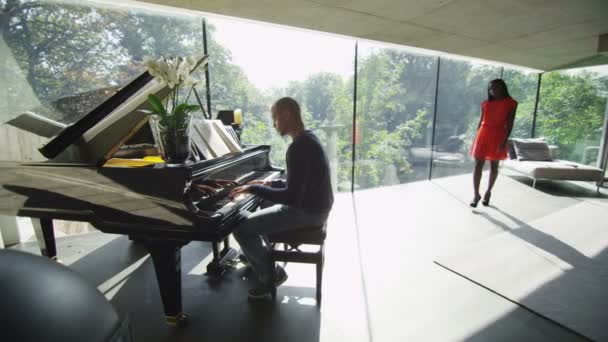 Adam kız arkadaşı dinler gibi piyano çalıyor — Stok video