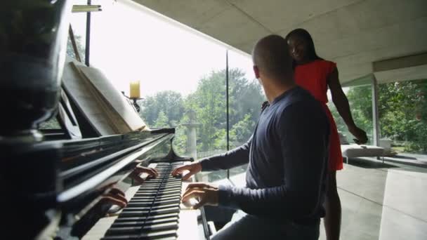 Homem toca piano enquanto sua namorada escuta — Vídeo de Stock