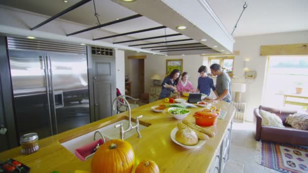 Familia siguiendo la receta y preparando alimentos — Vídeo de stock