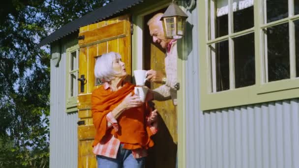 Senior couple relaxing outside quaint caravan — Stock Video