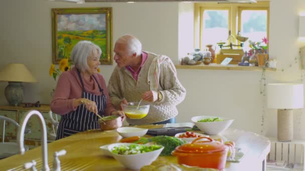 Heureux couple de personnes âgées préparer la nourriture ensemble — Video