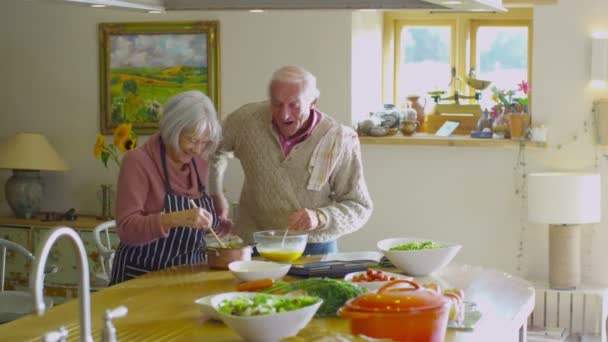 Glückliches Seniorenpaar bereitet gemeinsam Essen zu — Stockvideo