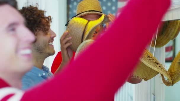 Friends trying on selection of straw hats — Stock Video