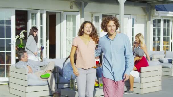 Couple socializing with friends outside beachside home — Stock Video