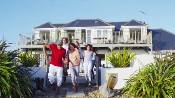 Amigos correm para a praia de casa à beira-mar — Vídeo de Stock