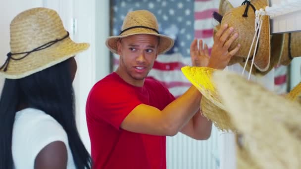 Couple trying on selection of straw hats — Stock Video