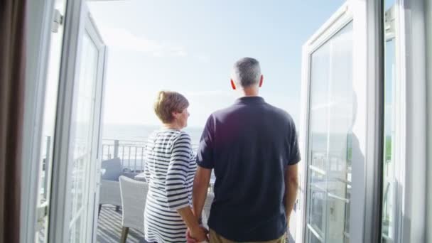 Mature couple go to look from balcony — Stock Video