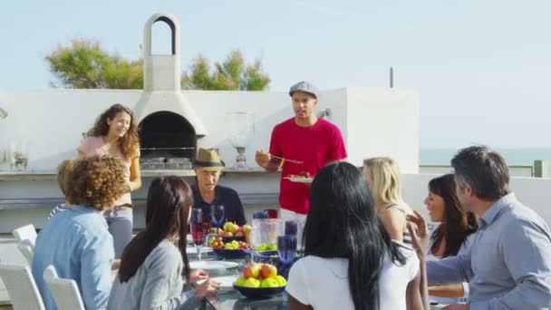 Familia y amigos disfrutando de la comida al aire libre — Vídeos de Stock