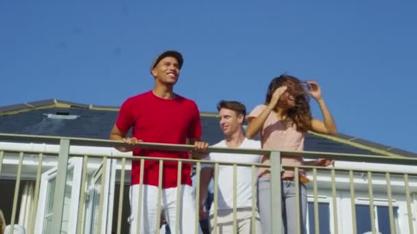 Друзья в отпуске выходят на балкон — стоковое видео