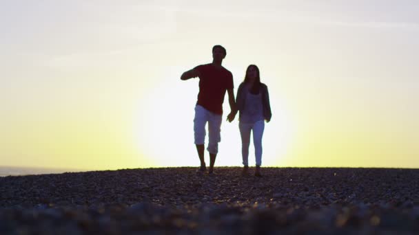 Paar hält Händchen und geht am Strand spazieren — Stockvideo