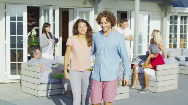 Pareja socializando con amigos fuera de casa junto a la playa — Vídeos de Stock