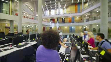 öğrenci grubu bilgisayarları ile dolu oda içinde