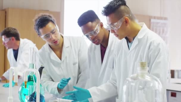Estudiantes trabajando juntos en clase de ciencias — Vídeo de stock