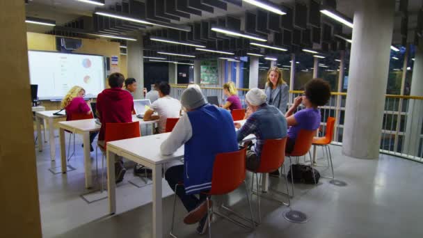 Professor ajudando alunos com estudos — Vídeo de Stock