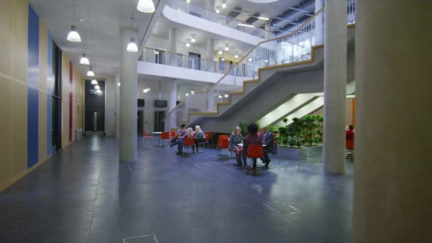Students sitting in communal area, university — Stock Video