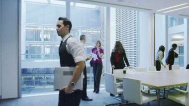 Büyük, modern bir ofis binasında yönetim kurulu toplantısında bir iş ekibi.