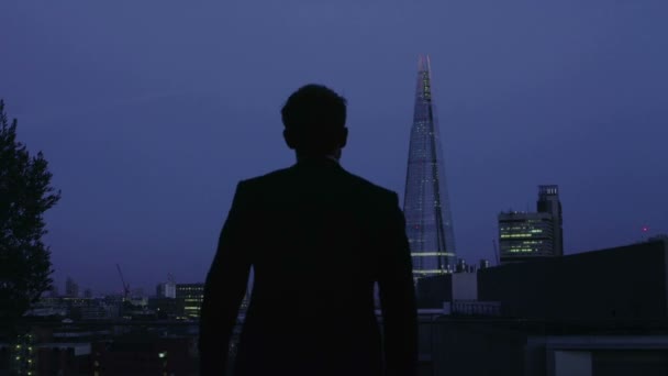 Επιτυχημένος επιχειρηματίας εξετάζει τη θέα στον ορίζοντα της πόλης Λονδίνο τη νύχτα — Αρχείο Βίντεο