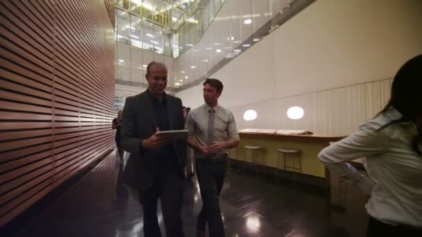 Business group walking through lobby — Stock Video