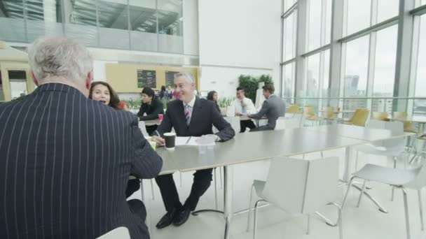 Mensen uit het bedrijfsleven bespreken in bedrijf kantine — Stockvideo