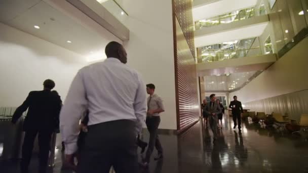 Business group walking through lobby — Stock Video