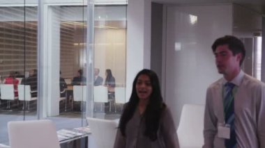 Büyük, modern bir ofis binasında yönetim kurulu toplantısında bir iş ekibi.