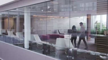 Büyük, modern bir ofis binasında yönetim kurulu toplantısında bir iş ekibi.