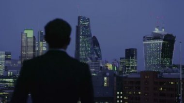 başarılı bir iş adamı Londra şehir manzarası görünümü geceleri dışarı bakar
