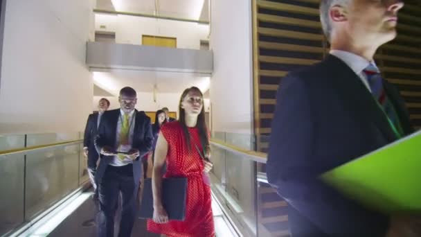Atractivo y diverso grupo de negocios caminando por el concurrido edificio de oficinas por la noche — Vídeos de Stock