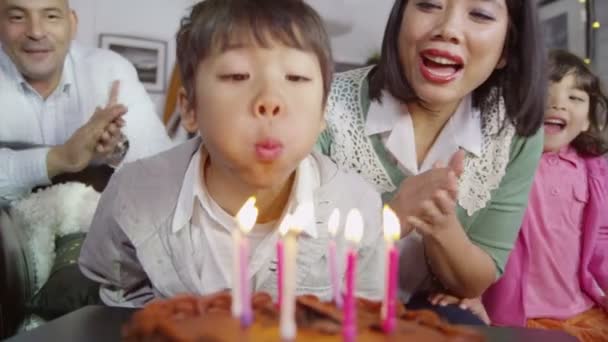 Мальчик задувает свечи на день рождения — стоковое видео