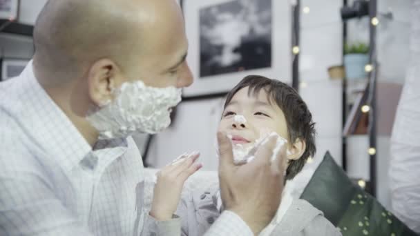 Father teaches son apply shaving foam — Stock Video