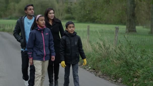 Familia feliz de cuatro personas dando un paseo por un espacio verde local — Vídeos de Stock